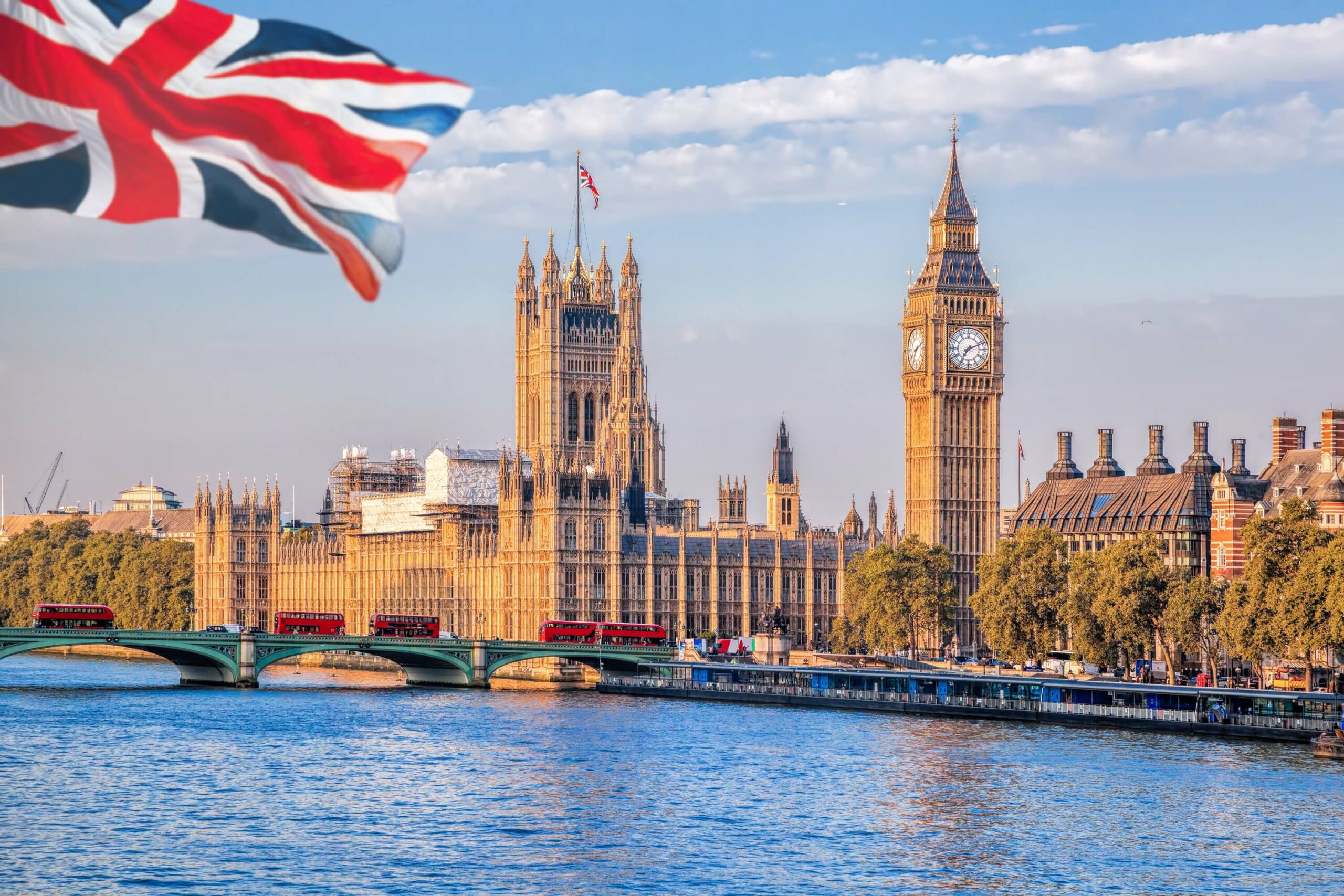 The British flag is flying over Big Ben and the Houses of Parliament in London, a must-see sight for travelers visiting the city.