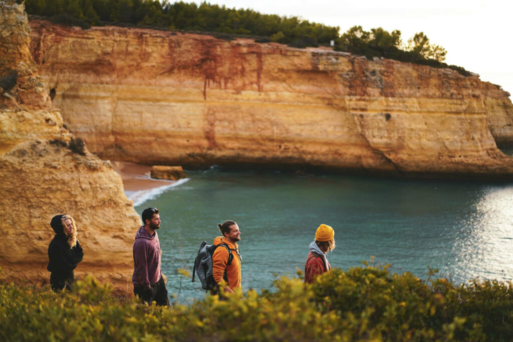 Photo of a group of tourists walking near a hidden beach during a tour in Portimao, Portugal.