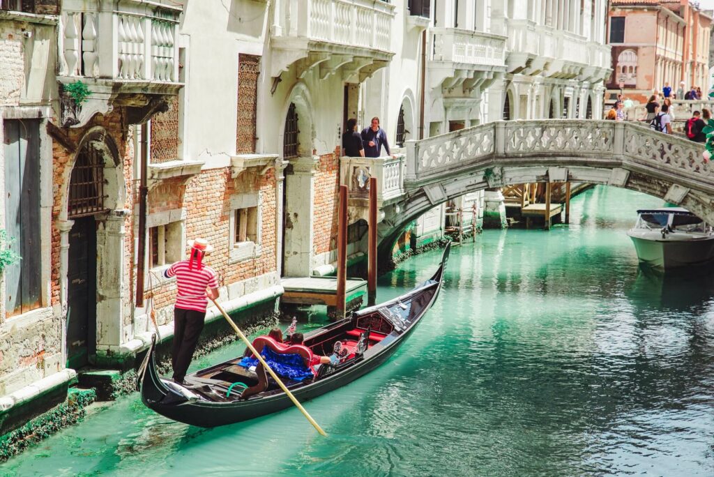 Photo of a couple enjoying a gondola ride in Venice, Italy.