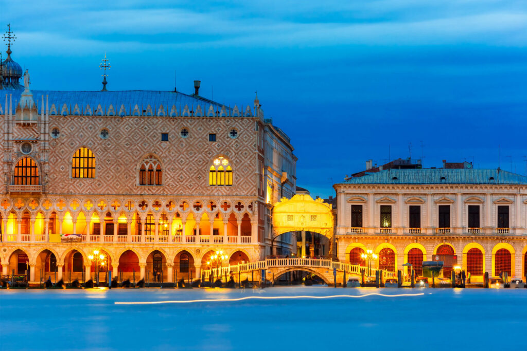 A photo showing the exterior of Doge's Palace in Venice lit up at night.