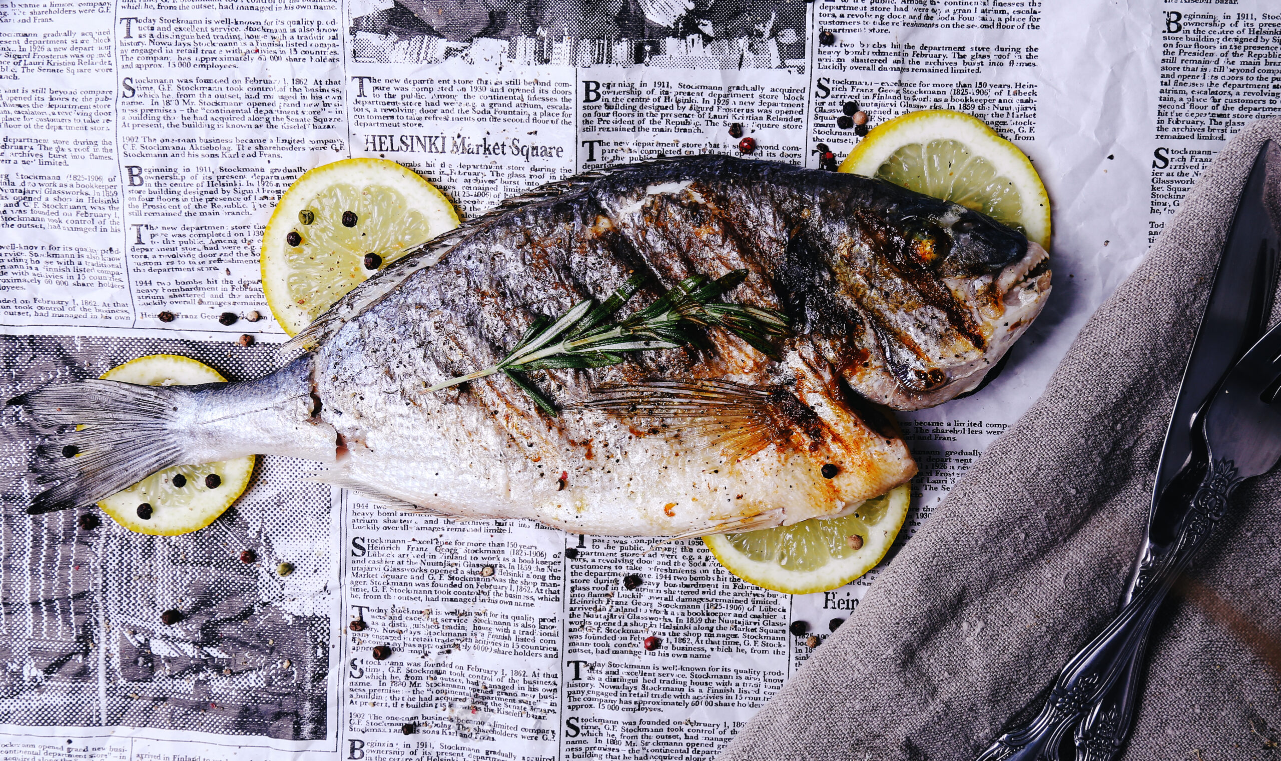 grilled goldenbream with slices of lemon and rosemary