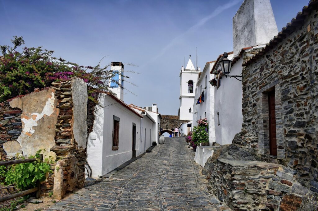 narrow streets with tiny white houses and cobble stone walls 