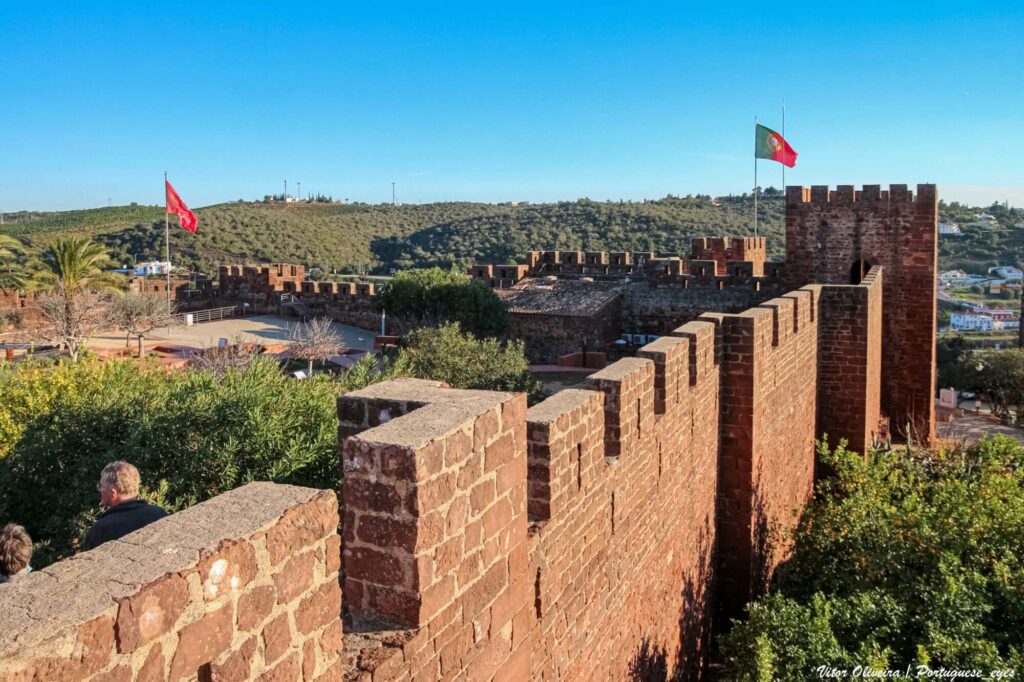 Walls of old moorish fortress surrounded by trees and a blue sky
