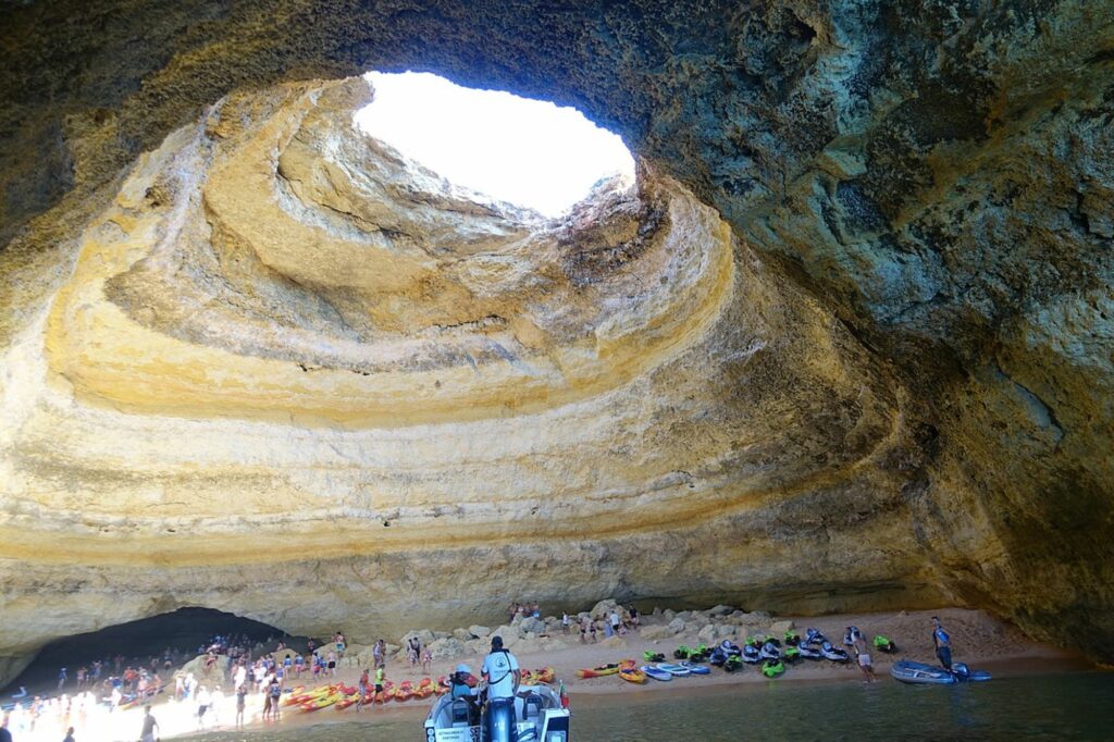 Cave with a hole at the top with sunlight coming in, at a secluded beach
