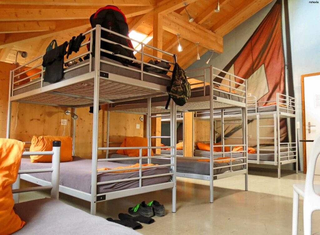 shared bedroom with multiple beds, cozy wooden walls and ceilings