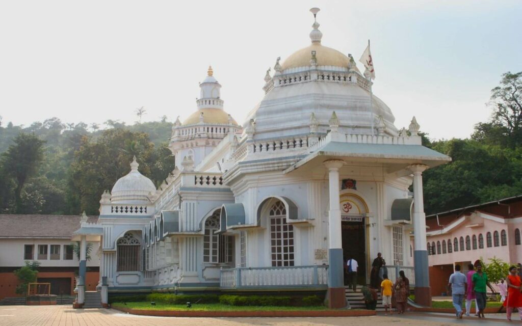 white Indian temple surrounded by green vegetation