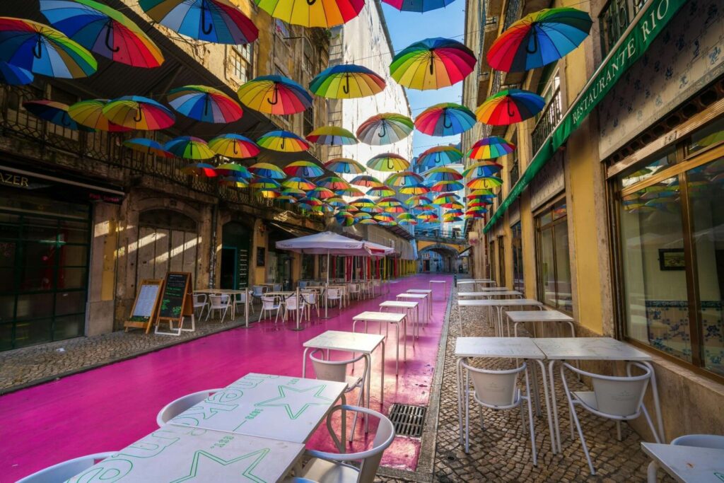 pink street with umbrellas serving as rooftops for decor, outside white tables for dining.
